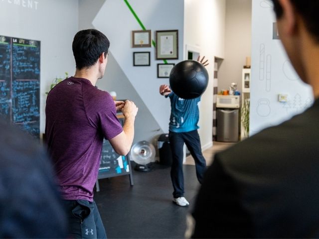 Vancouver chiropractor receiving a medball pass from a physio